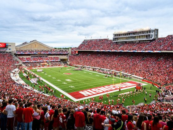 Picture of Camp Randall and Barry Alverez Field. The stadium is full of fans, mostly in red. The fans are watching a football game.