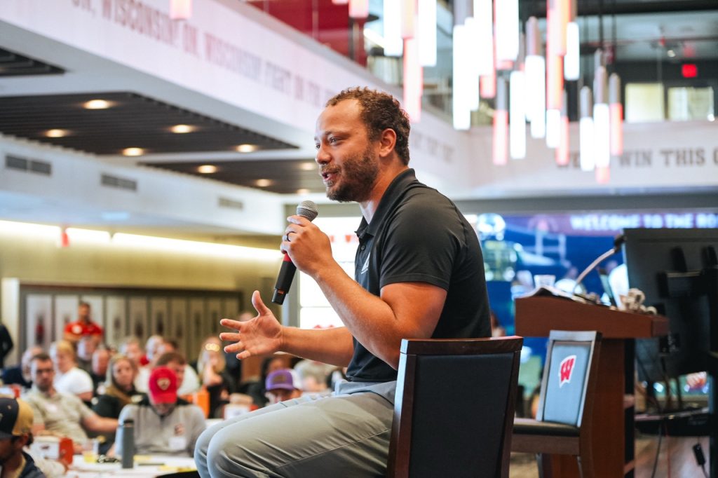 DSC09358 Large Former Badger and NFL player Alec Ingold speaks to Symposium participants while seated on stage at Camp Randall Stadium.